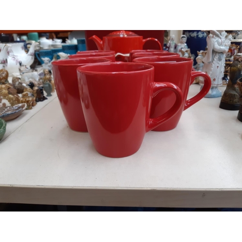 215 - An assortment of red kitchenalia to include a three piece Le Crueuset tea set, set of seven Ethos te... 