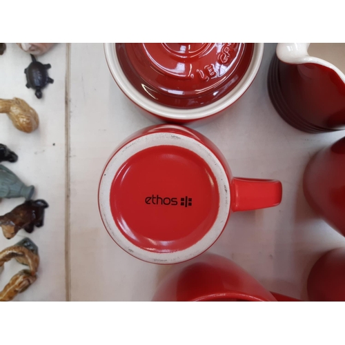 215 - An assortment of red kitchenalia to include a three piece Le Crueuset tea set, set of seven Ethos te... 