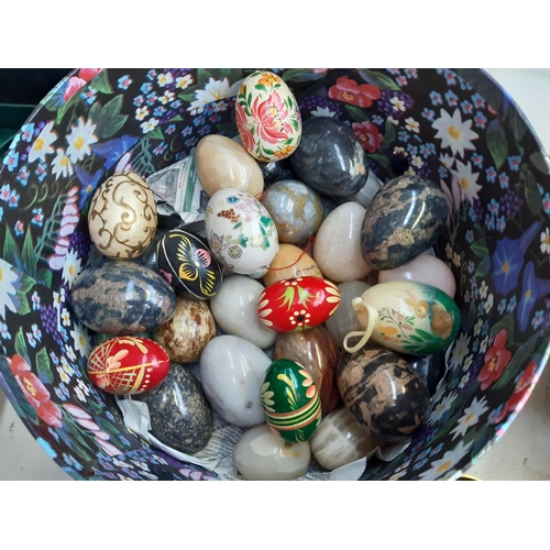 279 - A box containing a large collection of egg shaped ornaments to include semi precious stone examples,... 