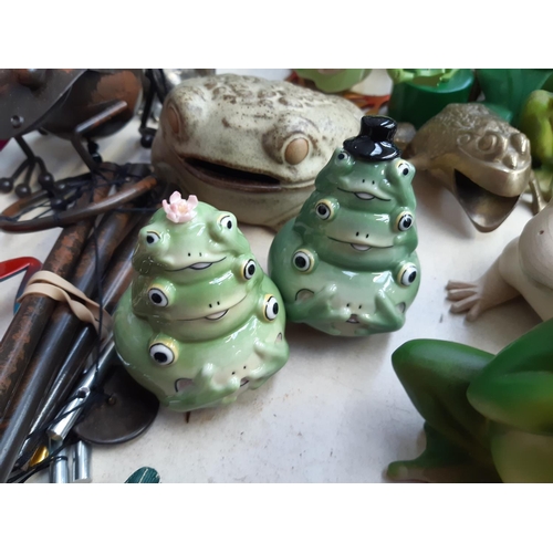 281 - A collection of frog ornaments to include ceramic, metal, wooden and fabric examples