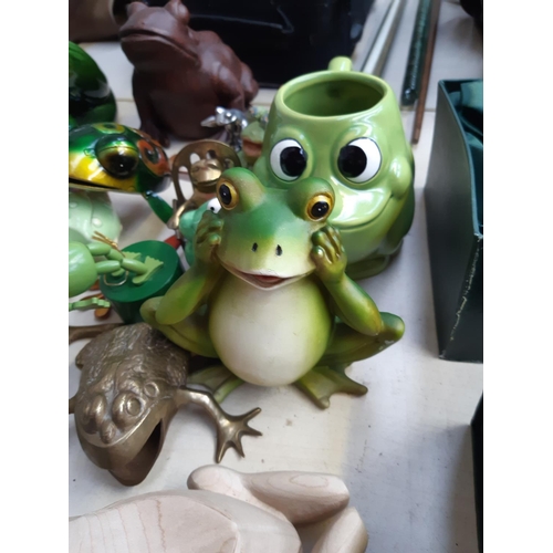 281 - A collection of frog ornaments to include ceramic, metal, wooden and fabric examples