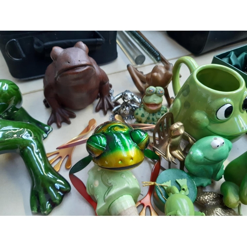 281 - A collection of frog ornaments to include ceramic, metal, wooden and fabric examples