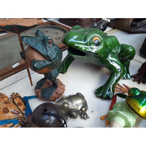 281 - A collection of frog ornaments to include ceramic, metal, wooden and fabric examples