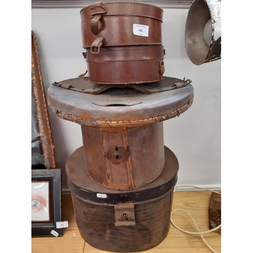 342 - Four vintage boxes to include a black metal top hat box, brown leather top hat box and two brown lea... 