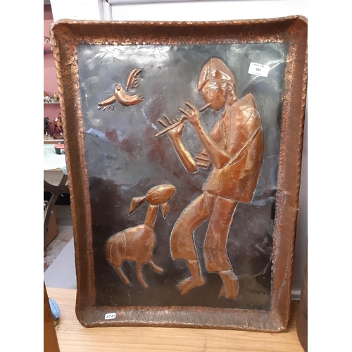 345 - A decorative copper Arts & Crafts wall plaque with man playing flute to lamb - measuring approx. 65c... 