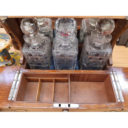 349 - A good quality Victorian oak tantalus with brass details, three cut glass decanters and inner storag... 