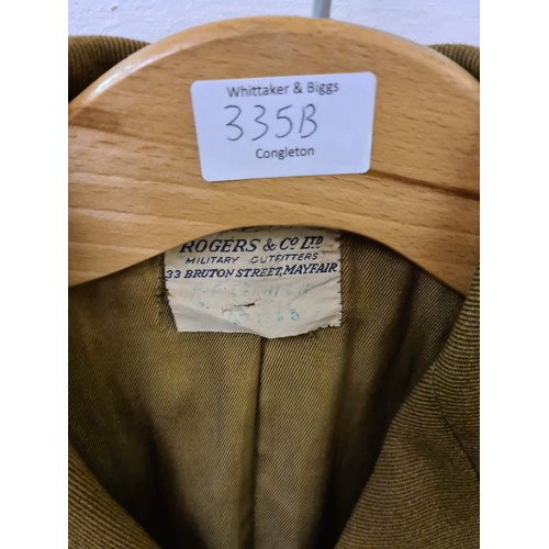 335B - A Rogers & Co. Ltd military dress jacket with brass buttons and blue and red striped trousers