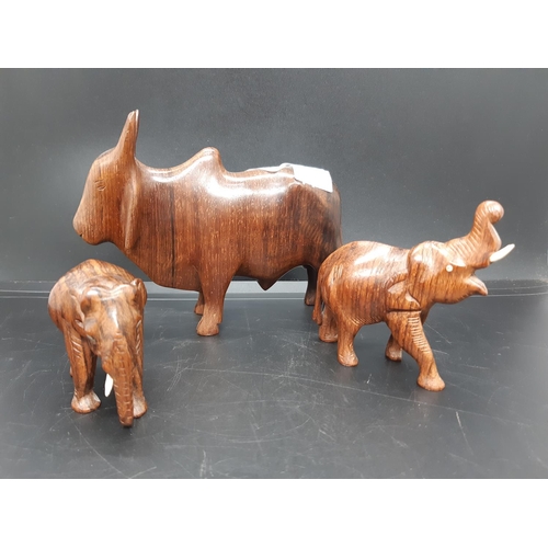 59 - Three carved treen animal figurines to include two elephants and a Zebu Bull