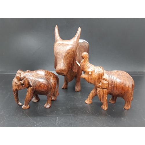 59 - Three carved treen animal figurines to include two elephants and a Zebu Bull