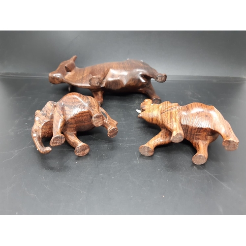 59 - Three carved treen animal figurines to include two elephants and a Zebu Bull