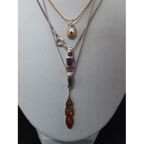 61 - Three ladies necklaces to include a hallmarked 925 silver with inset amber pendant, a hallmarked 925... 