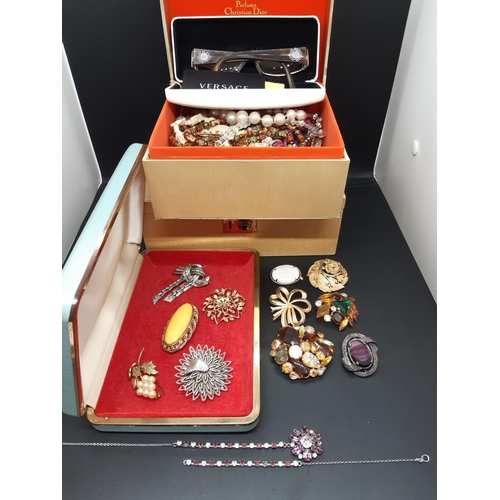 76 - Three boxes containing various vintage costume jewellery and a pair of boxed Versace ladies reading ... 