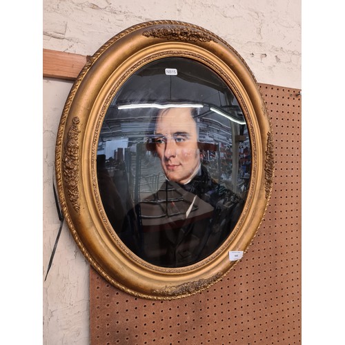 445 - A 19th century gilt framed oval oil on glass portrait of a gentleman