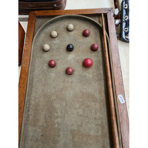 282 - An early 20th century oak framed 9 ball table top Bagatelle game and cue