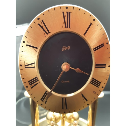 129 - A vintage brass effect Schatz West German Quartz anniversary clock with glass dome