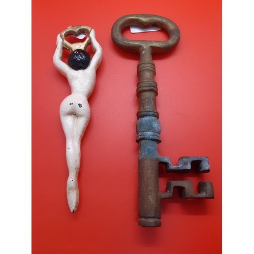 66 - Two items to include a large brass novelty key and a hand painted cast iron bottle opener in the for... 