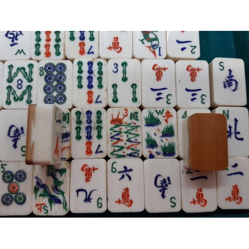 122 - An early 20th century leather cased Chinese Mahjong set with tiles, counters etc. - each tile measur... 