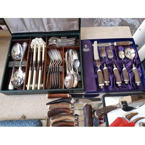 165E - A large collection of cased and loose vintage cutlery to include antler handled cutlery, teaspoons, ... 