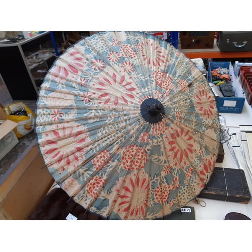 300 - Five items to include a 19th century silk parasol with ivory top, two oriental paper parasols, one o... 