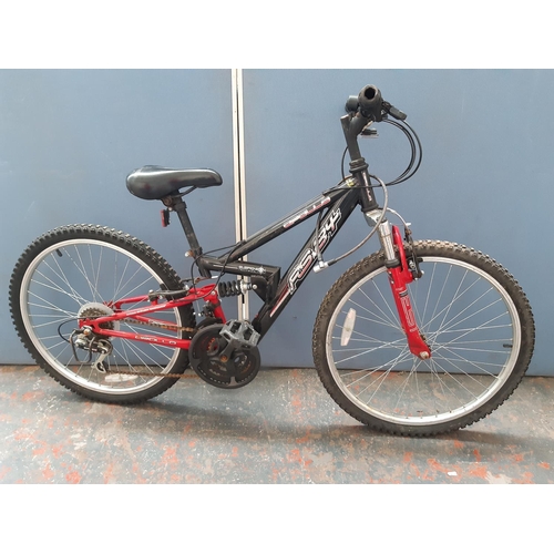 A black and red Apollo FS24 dual suspension boys mountain bike with 18 speed Shimano gear system