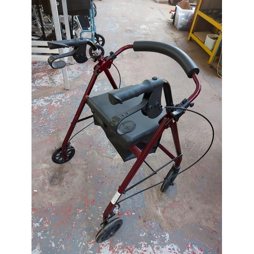 1023 - A black and red drive four wheeled walking aid with brakes