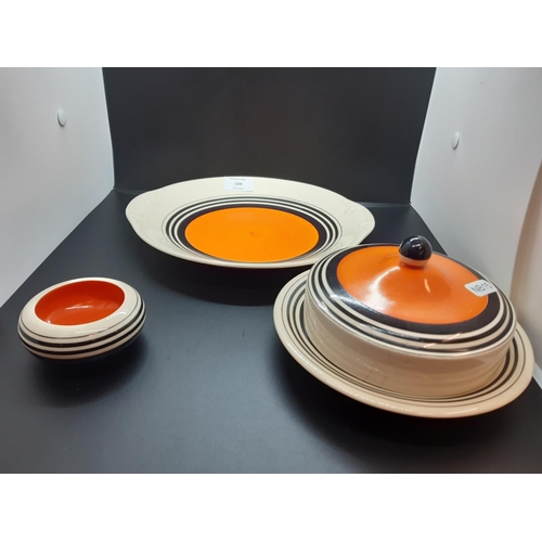 104 - Three pieces of Susie Cooper Production Crown Works pottery to include cake plate, cheese dome and c... 