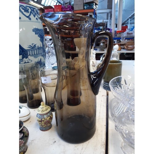 194 - A 1970s hand blown smoked glass water jug and six matching glasses