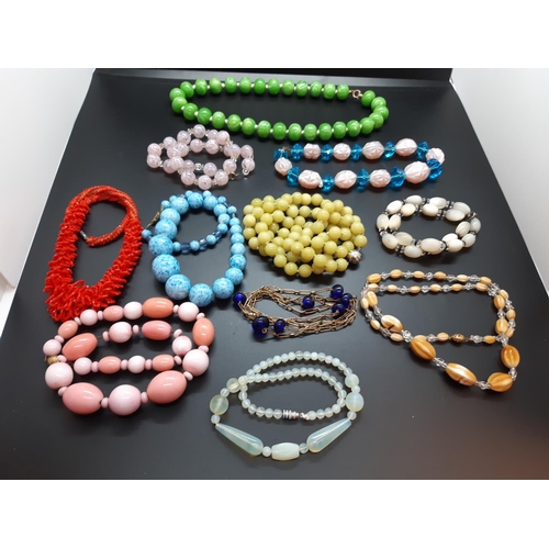 59 - A collection of mid 20th century necklaces to include ceramic, vaseline glass and mother of pearl