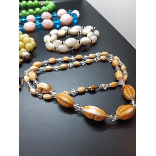 59 - A collection of mid 20th century necklaces to include ceramic, vaseline glass and mother of pearl