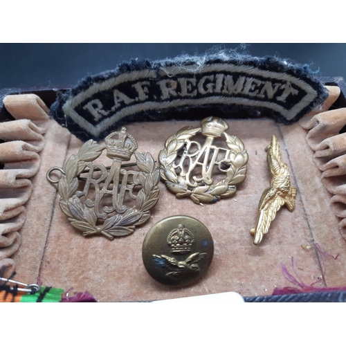 84 - A box containing various militaria to include two R.A.F cap badges, R.A.F Regiment shoulder patch, m... 