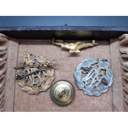 84 - A box containing various militaria to include two R.A.F cap badges, R.A.F Regiment shoulder patch, m... 