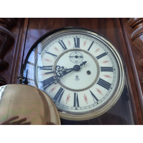 250 - A Victorian walnut cased chiming Vienna wall clock with cream enamel face, Roman numerals, pendulum ... 