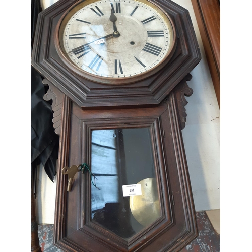 252 - An American Ansonia Clock Company of New York oak cased 8 day wall clock with Roman numerals, pendul... 