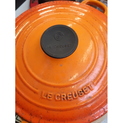 277 - Three Le Creuset orange cooking pans to include two lidded saucepans and a casserole dish