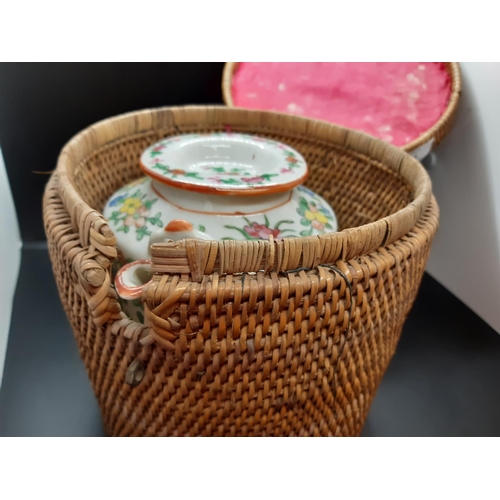 121 - An early 20th century oriental wicker teapot warming basket containing famille rose teapot (see cond... 