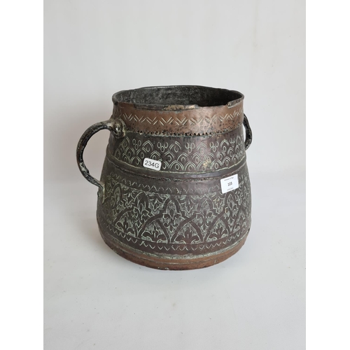 103 - A Middle Eastern hand engraved copper twin handled cauldron - approx. 29cm high