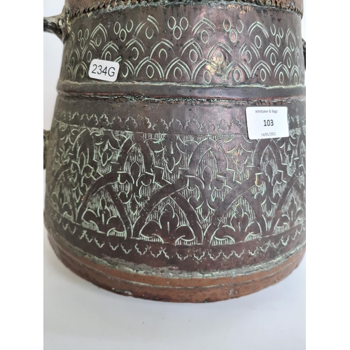 103 - A Middle Eastern hand engraved copper twin handled cauldron - approx. 29cm high