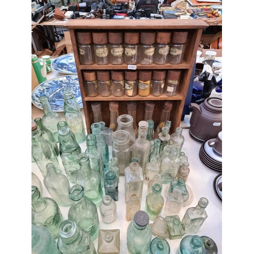 141 - A large collection of assorted vintage glass bottles to include Veno's cough cure, Coffee etc. and a... 