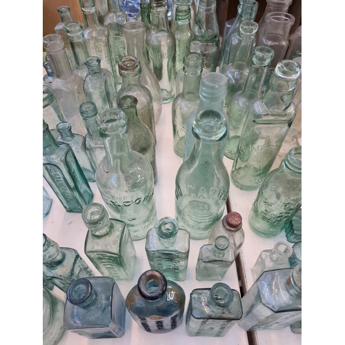 141 - A large collection of assorted vintage glass bottles to include Veno's cough cure, Coffee etc. and a... 