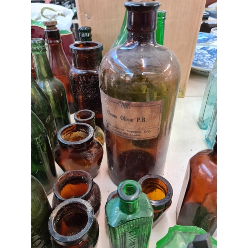 142 - A collection of assorted vintage coloured glass bottles to include Evans Oleum Olivae, Robert Browns... 