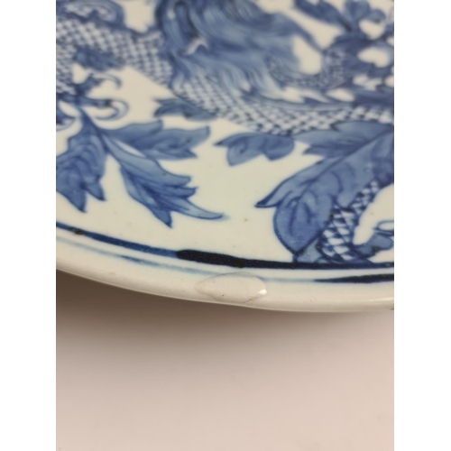 153 - A late 19th/early 20th century Chinese blue and white porcelain wall charger with dragon design - ap... 