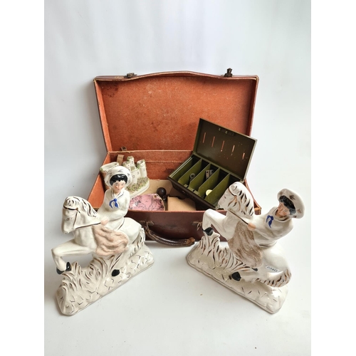 186 - A vintage brown leather case containing various items to include two Staffordshire pottery horse rid... 