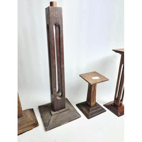 217 - Four items to include three vintage oak candle stands and one vintage table lamp base