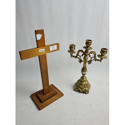 251 - Two items to include a brass three branch candelabra and a wooden religious cross