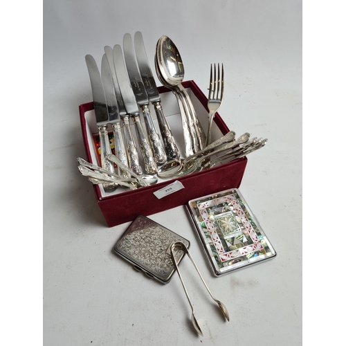 255 - A box containing various items to include a pair of hallmarked Sheffield silver sugar tongs - approx... 