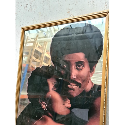 284a - A gilt framed loving couple mirror - approx. 54cm x 75cm