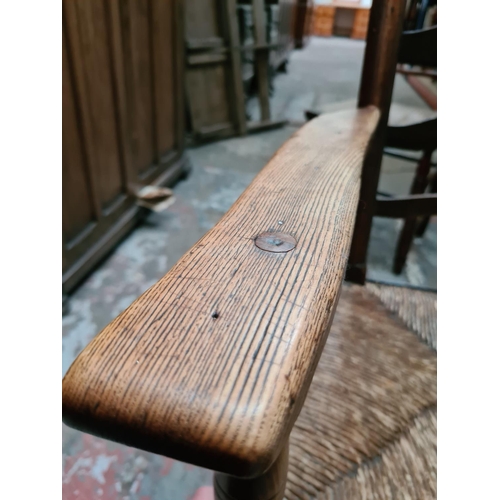 312 - Two 19th century elm farmhouse chairs with rush seats to include one rocking chair