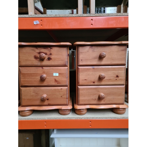 352 - A pair of modern pine three drawer bedside cabinets