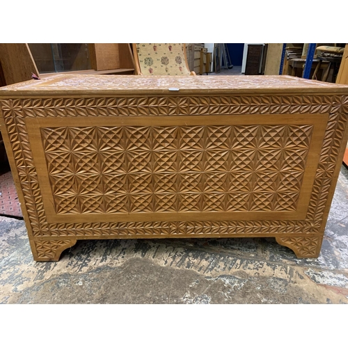 395 - Two items, a camphor wood carved blanket chest together with a beech rocking chair