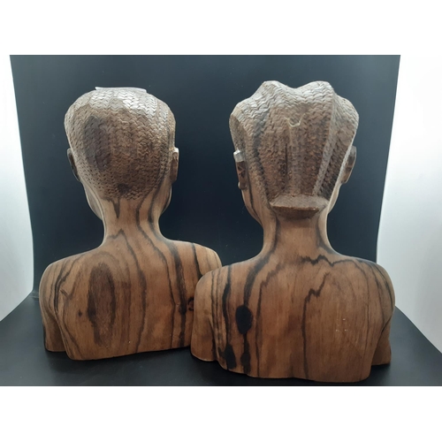 68 - A pair of mid/late 20th century carved lignum vitae African busts - approx. 21cm high